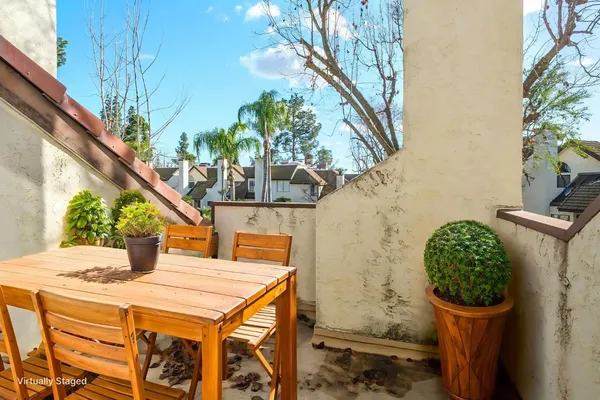 a balcony view with a table and chairs