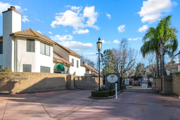 a front view of a house with a yard and potted plants