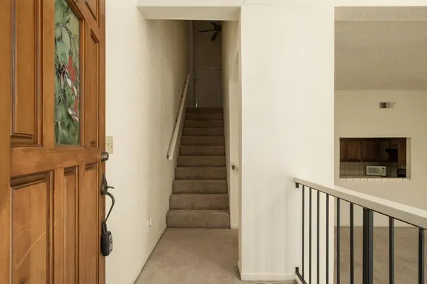 a view of a hallway with wooden floor and staircase
