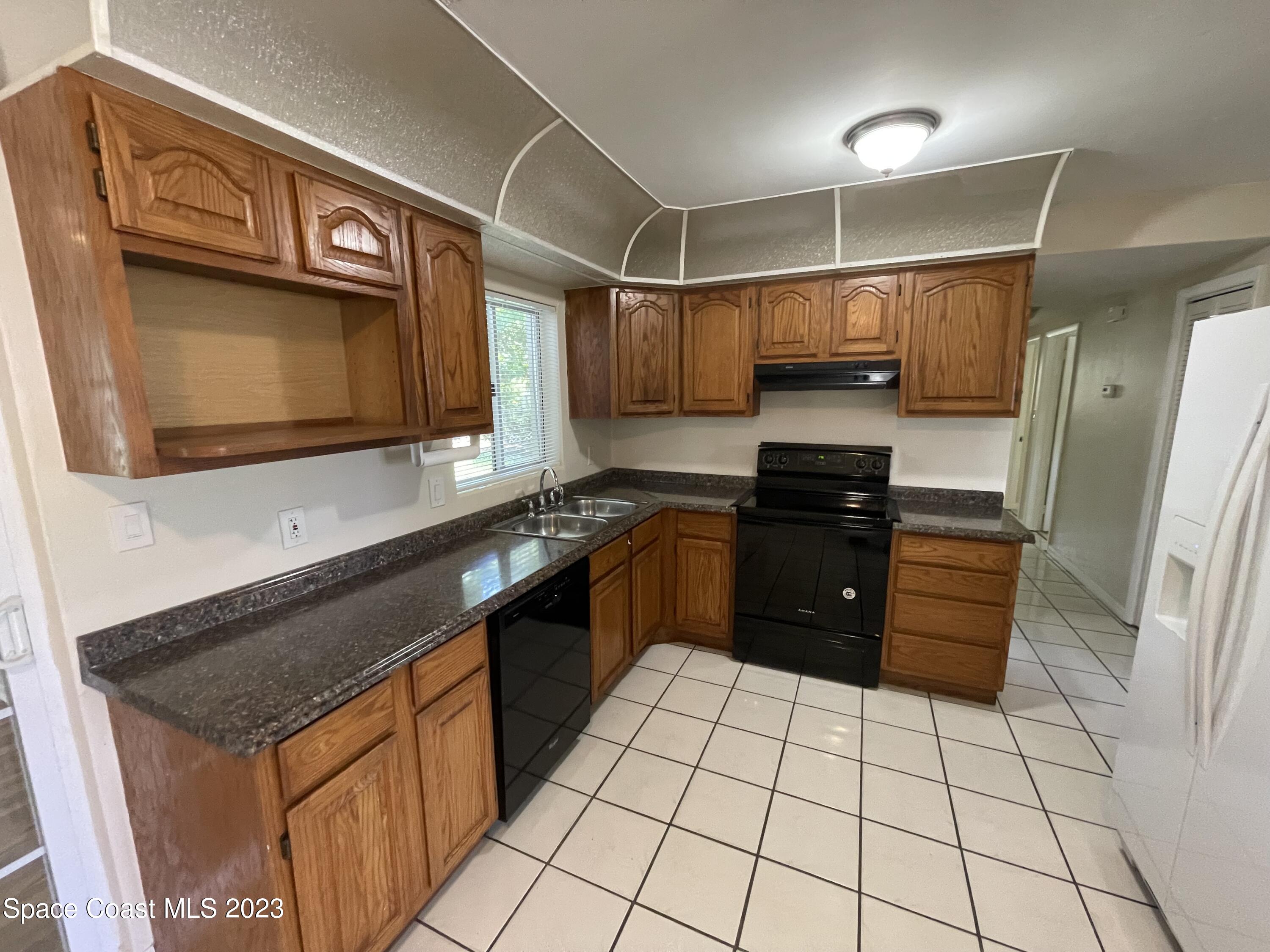 814 Hampton Way Merritt Island, FL 32953 - Photo 2 of 9 a kitchen with stainless steel appliances granite countertop a stove a sink and a microwave