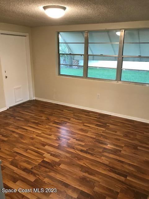 814 Hampton Way Merritt Island, FL 32953 - Photo 5 of 9 wooden floor in an empty room with a window