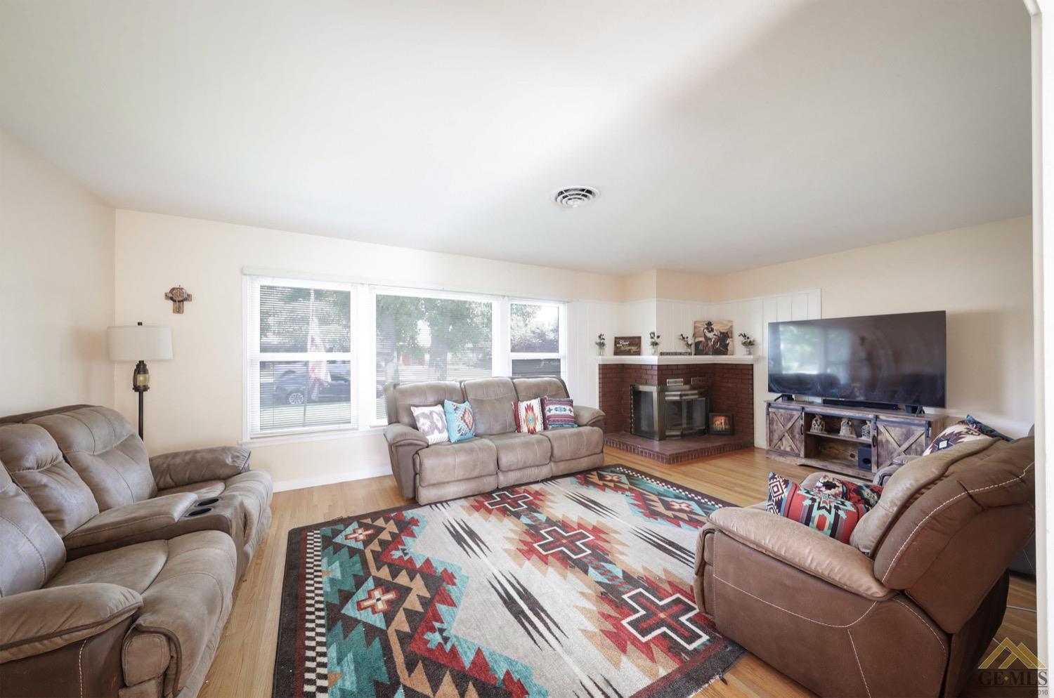 Undisclosed Address Bakersfield, CA 93308 - Photo 11 of 22 a living room with furniture a flat screen tv and a fireplace