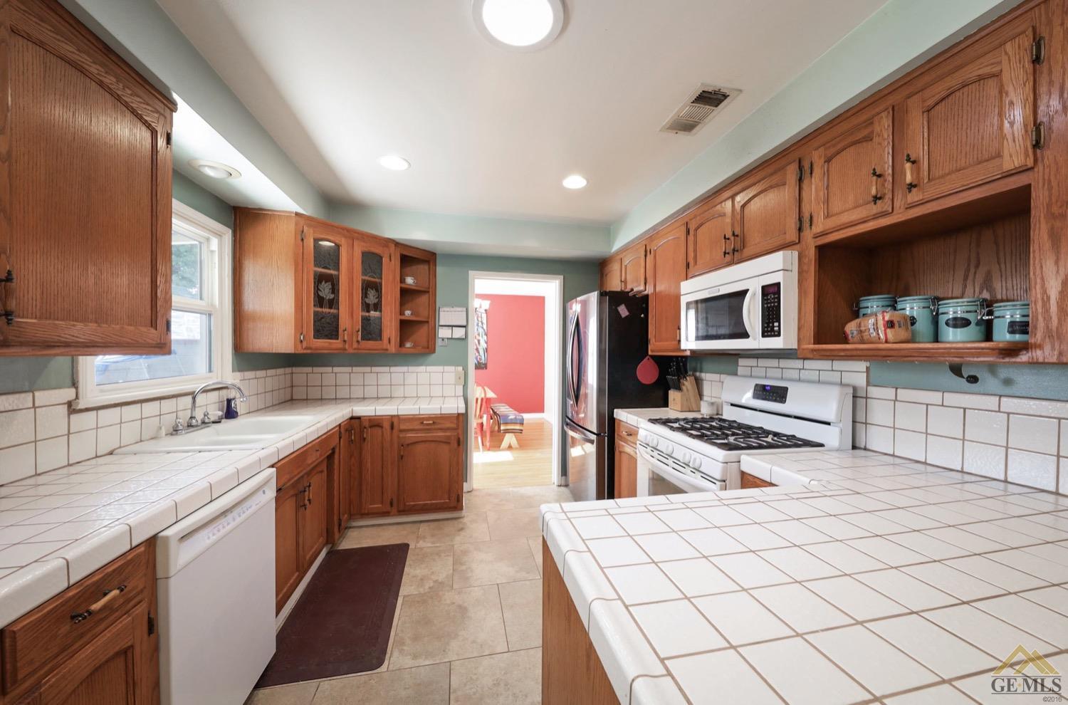 Undisclosed Address Bakersfield, CA 93308 - Photo 14 of 22 a large kitchen with stainless steel appliances granite countertop a sink and cabinets