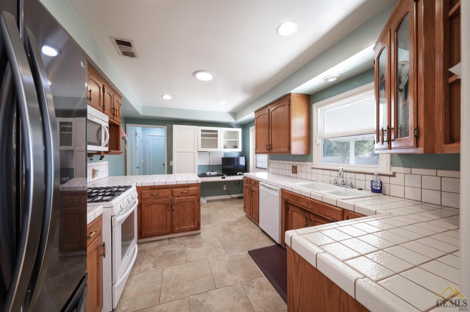 Undisclosed Address Bakersfield, CA 93308 - Photo 15 of 22 a kitchen with a sink stove and refrigerator