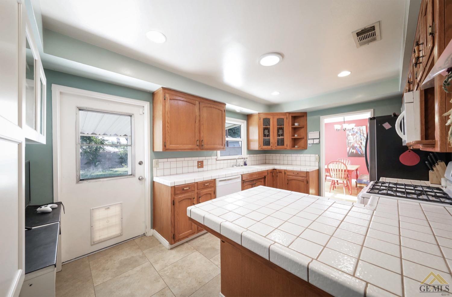 Undisclosed Address Bakersfield, CA 93308 - Photo 18 of 22 a large white kitchen with sink stove and refrigerator