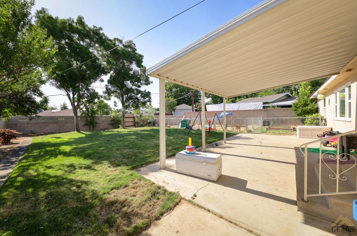 Undisclosed Address Bakersfield, CA 93308 - Photo 19 of 22 a view of a patio with table and chairs plants and large trees