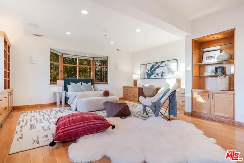 a bedroom with furniture and a large window