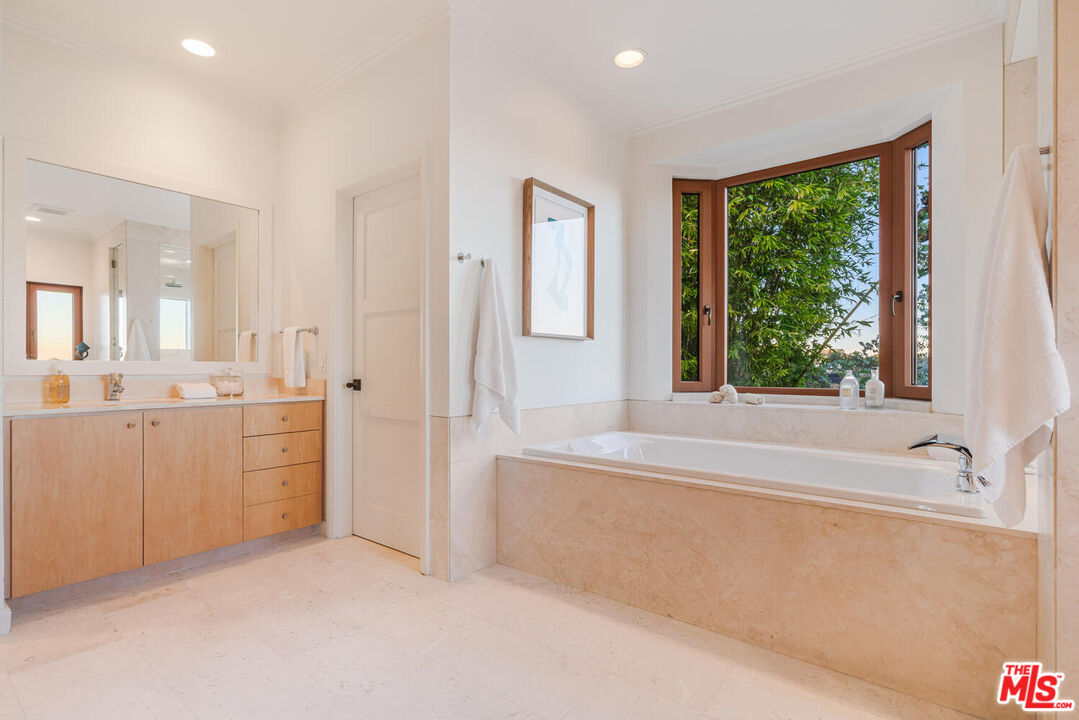 2232 Stradella Road Los Angeles, CA 90077 - Photo 30 of 48 a bathroom with a granite countertop sink mirror bathtub and next to a window
