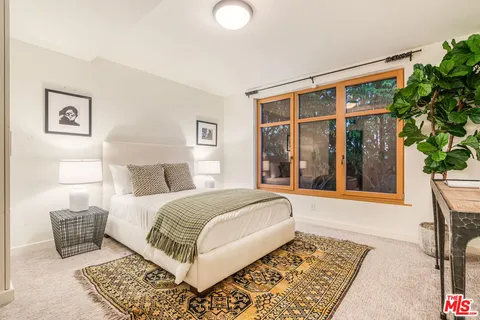 a bedroom with a large bed and a potted plant