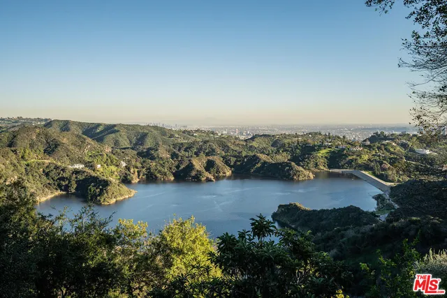 an aerial view of residential house with outdoor space and trees all around