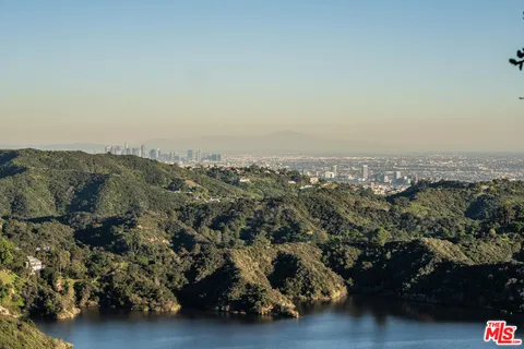 an aerial view of house with yard and mountain view in back
