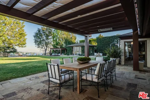 a view of a patio with a table chairs and a backyard