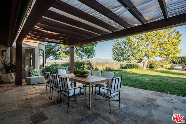 a view of an outdoor dining space with a table and chairs