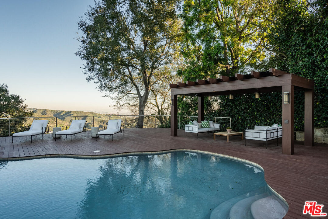2232 Stradella Road Los Angeles, CA 90077 - Photo 48 of 48 a view of a swimming pool with lawn chairs and couches