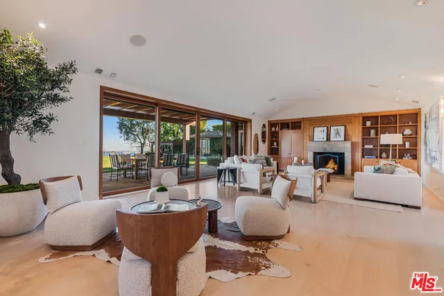 a living room with fireplace furniture and a large window
