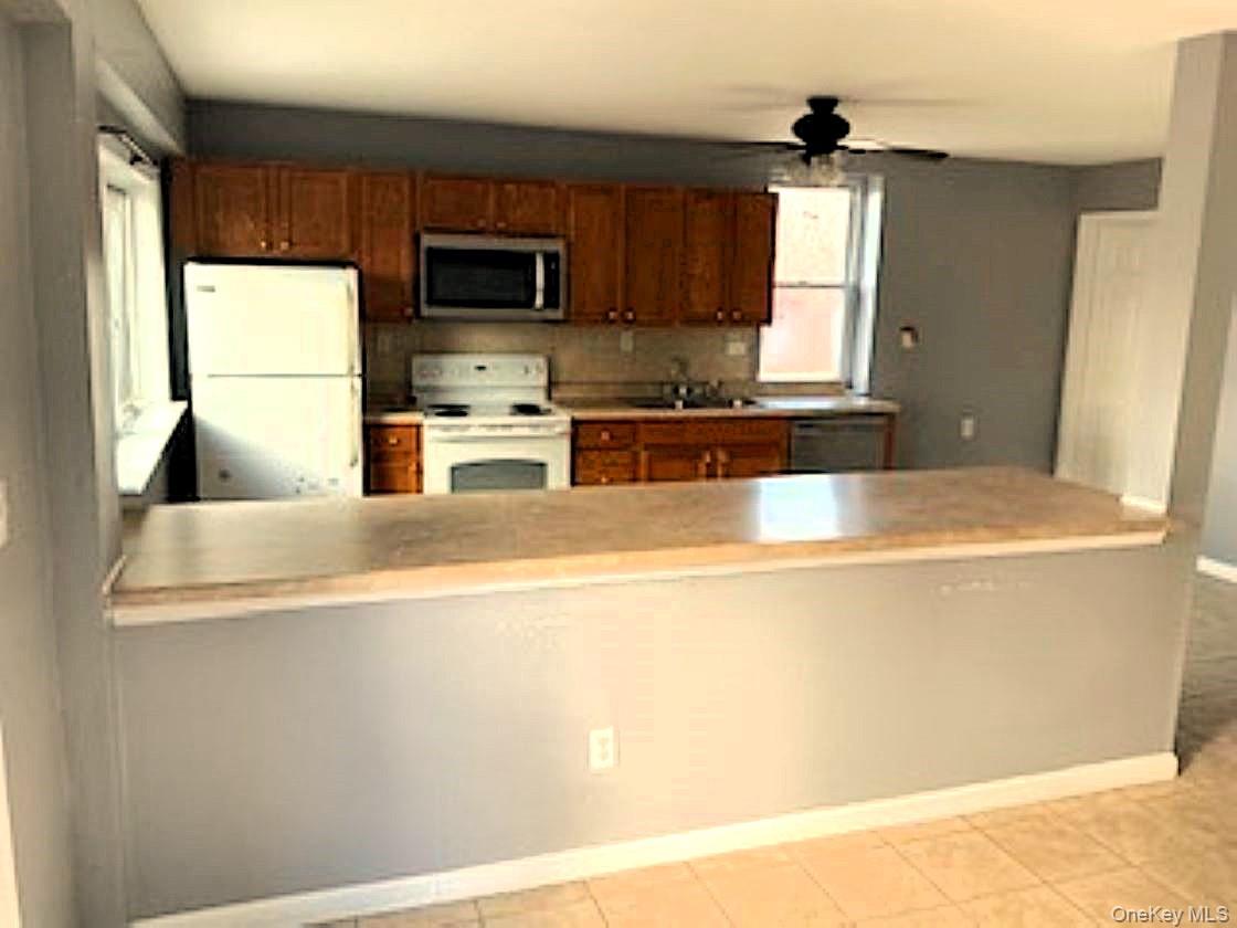 178 Pine Tree Road Monroe, NY 10950 - Photo 3 of 11 a kitchen with kitchen island a sink wooden floor and a large window