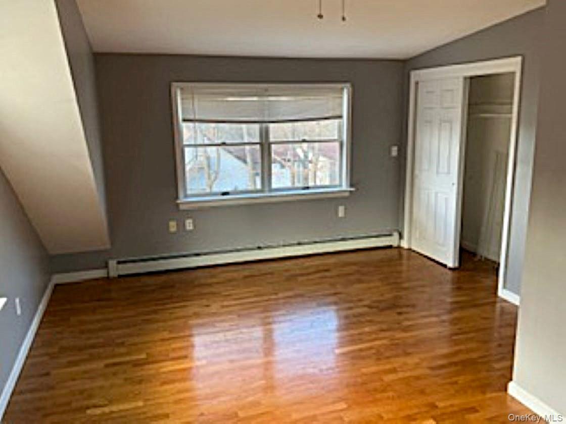 178 Pine Tree Road Monroe, NY 10950 - Photo 8 of 11 a view of an empty room with wooden floor and a window