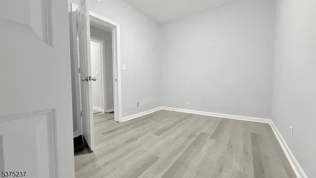 an empty room with wooden floor and closet