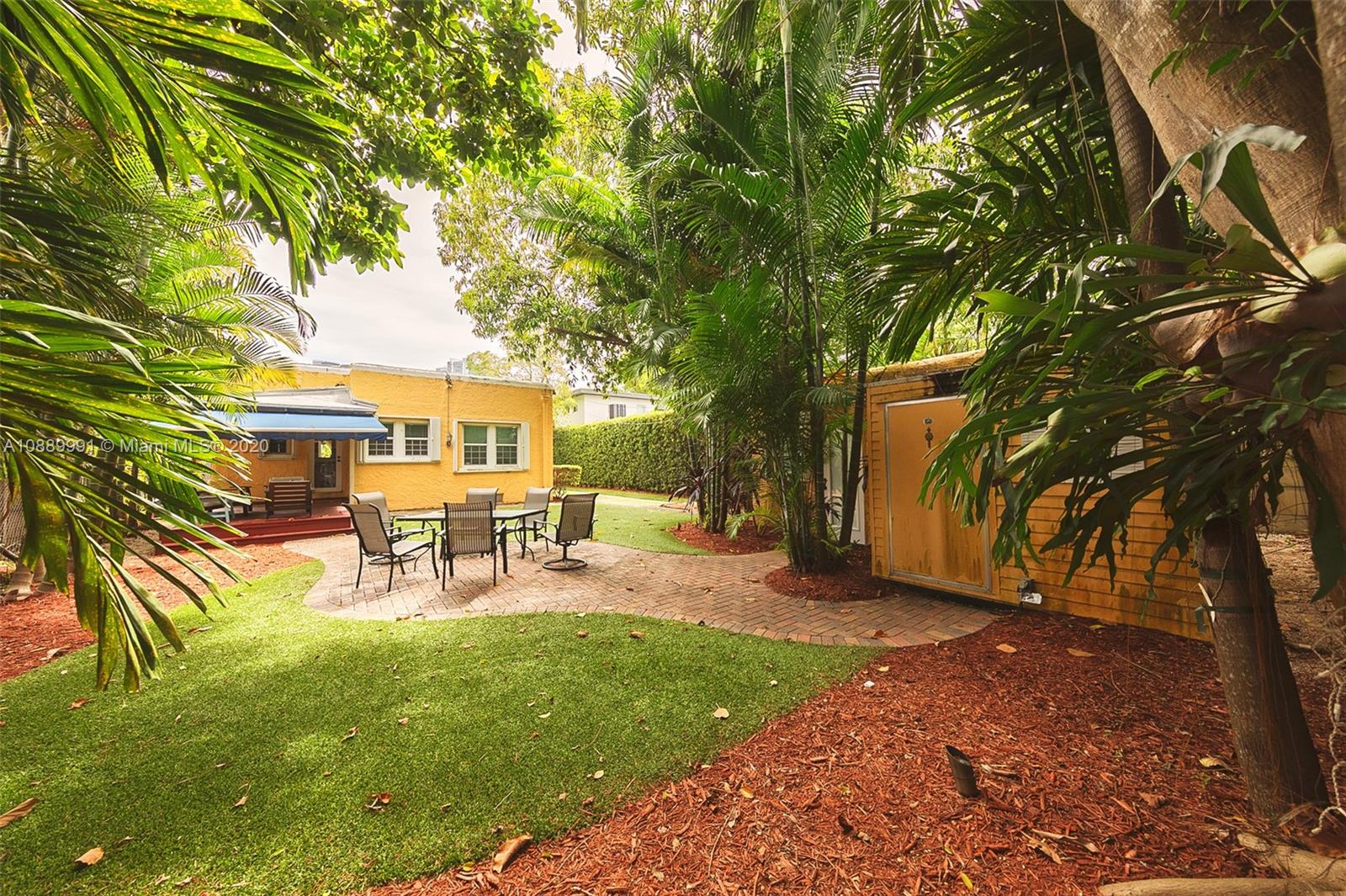 210 Southwest 19th Road Miami, FL 33129 - Photo 23 of 33 a view of a backyard with table and chairs and a tree