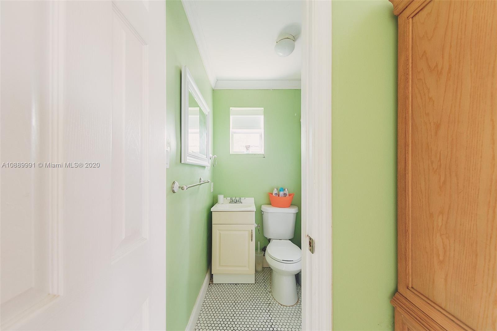 210 Southwest 19th Road Miami, FL 33129 - Photo 27 of 33 a white toilet sitting next to a bathroom sink and vanity