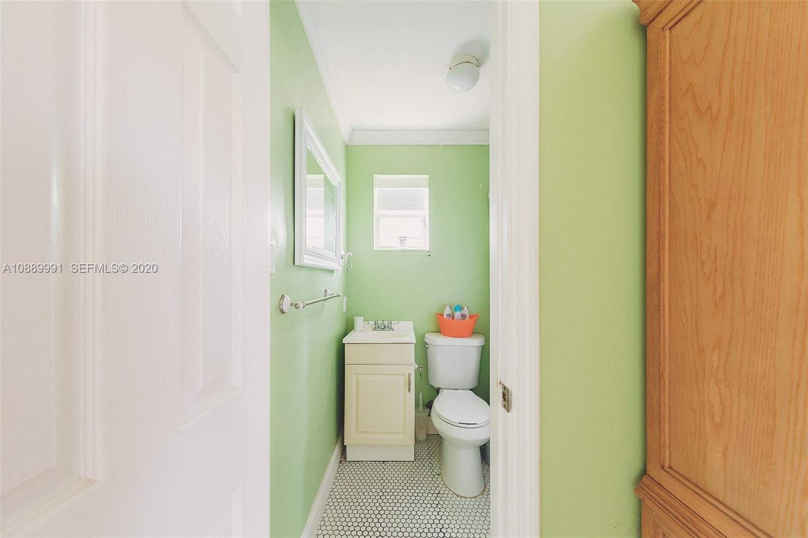 210 Southwest 19th Road Miami, FL 33129 - Photo 27 of 33 a white toilet sitting next to a bathroom sink and vanity