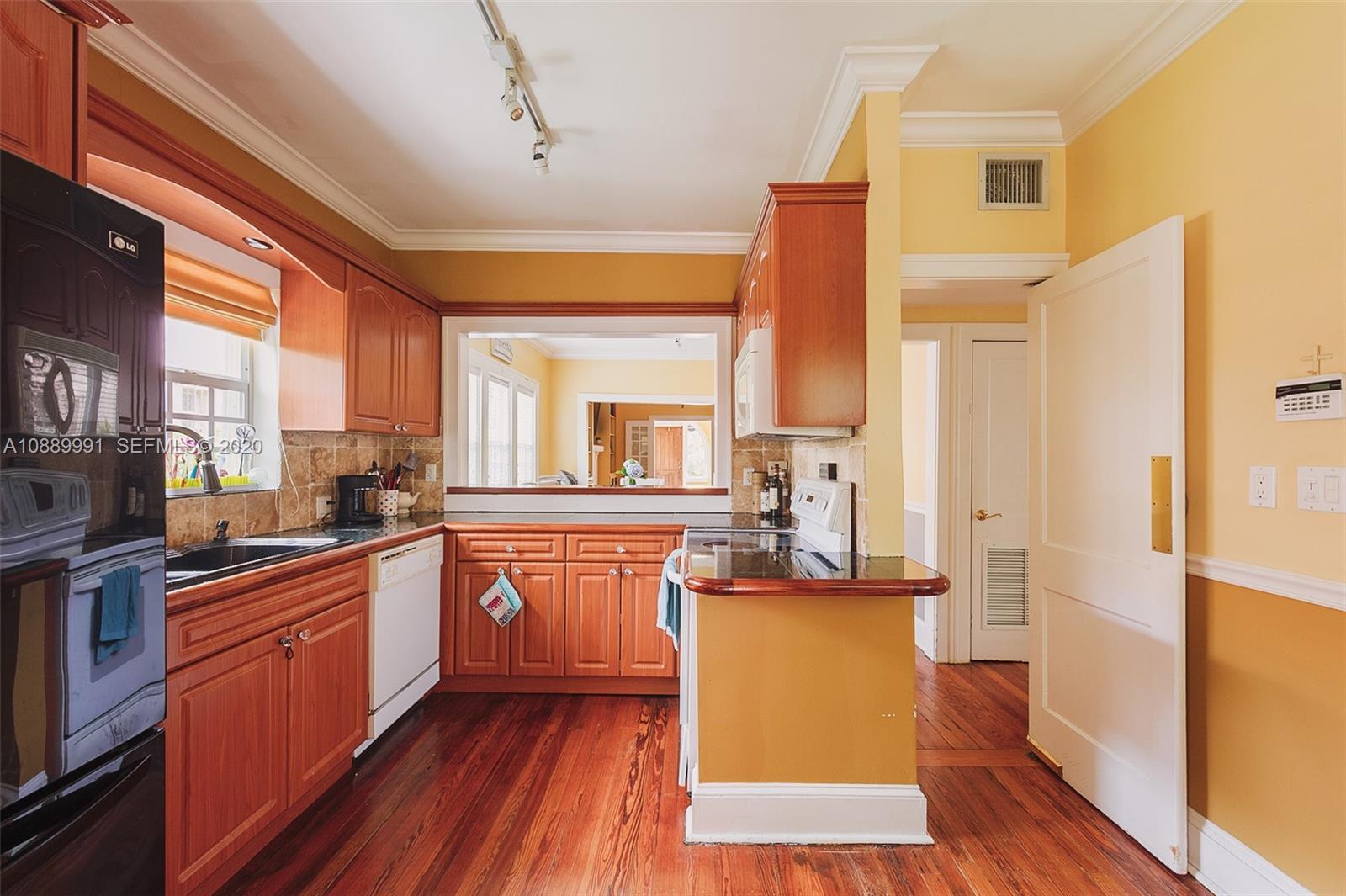 210 Southwest 19th Road Miami, FL 33129 - Photo 6 of 33 a kitchen with stainless steel appliances granite countertop a stove cabinets and wooden floor