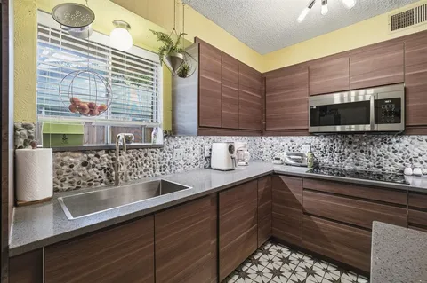 a kitchen with stainless steel appliances wooden cabinets a sink and a microwave