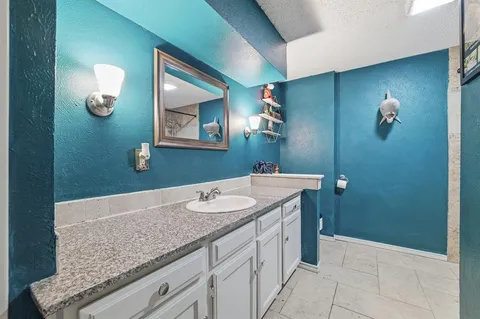 a bathroom with a granite countertop sink and mirror
