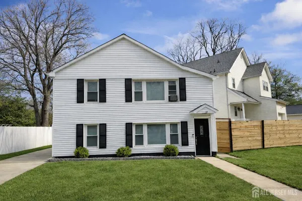 a front view of a house with a yard and trees