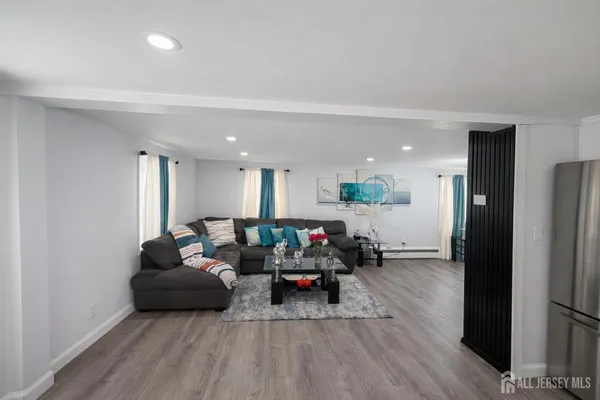 a living room with furniture and a wooden floor
