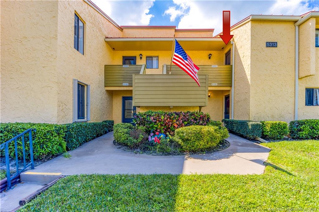 a front view of a house with a yard and potted plants