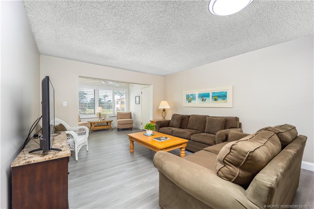 5313 Southeast Miles Grant Road, Unit K209 Stuart, FL 34997 - Photo 11 of 20 a living room with furniture and a flat screen tv