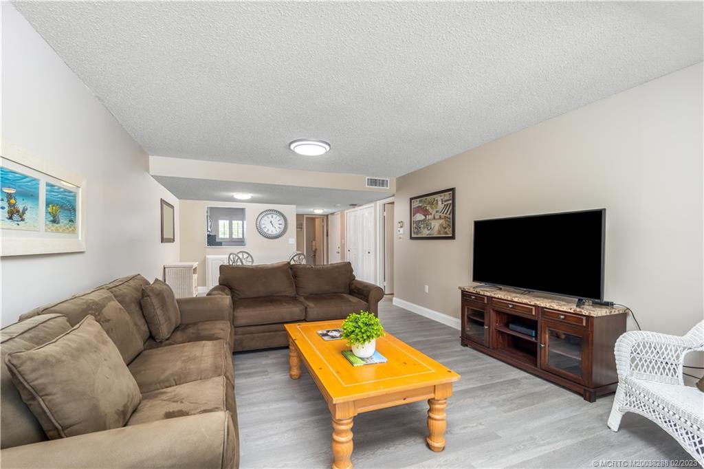 5313 Southeast Miles Grant Road, Unit K209 Stuart, FL 34997 - Photo 13 of 20 a living room with furniture and a flat screen tv