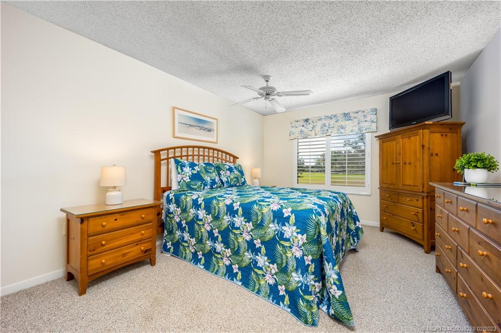5313 Southeast Miles Grant Road, Unit K209 Stuart, FL 34997 - Photo 14 of 20 a bedroom with a bed and a flat tv screen on dresser