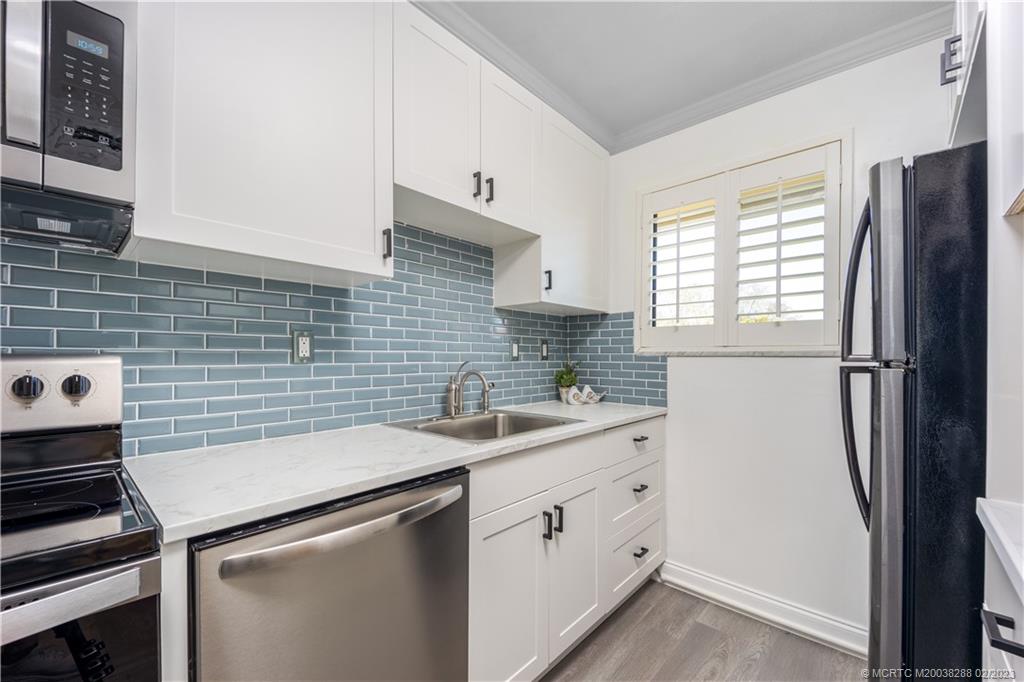 5313 Southeast Miles Grant Road, Unit K209 Stuart, FL 34997 - Photo 6 of 20 a kitchen with a sink stove and refrigerator