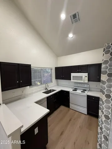 a kitchen with stainless steel appliances granite countertop a sink dishwasher stove top oven and refrigerator