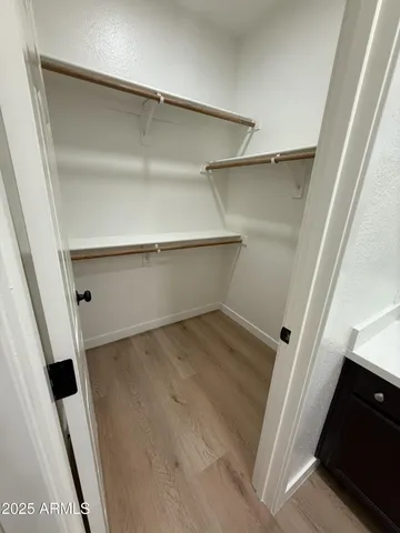 a view of walk in closet with empty racks