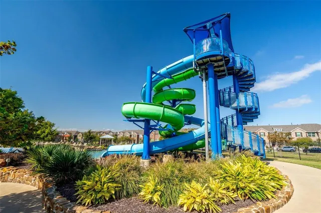 a view of a lake with a yard and large trees