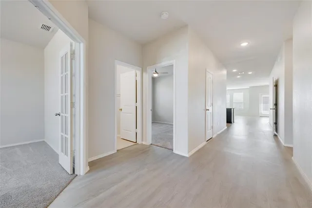 a view of a hallway with wooden floor