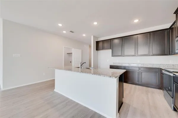 a kitchen with kitchen island sink stove and refrigerator