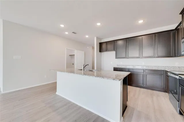 a kitchen with kitchen island sink stove and refrigerator