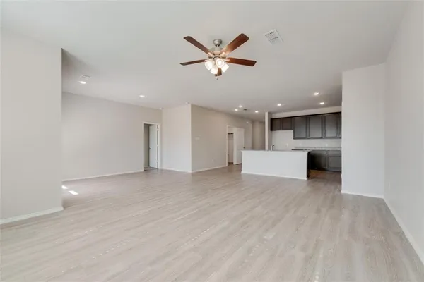 a view of a livingroom with a ceiling fan a ceiling fan and wooden floor