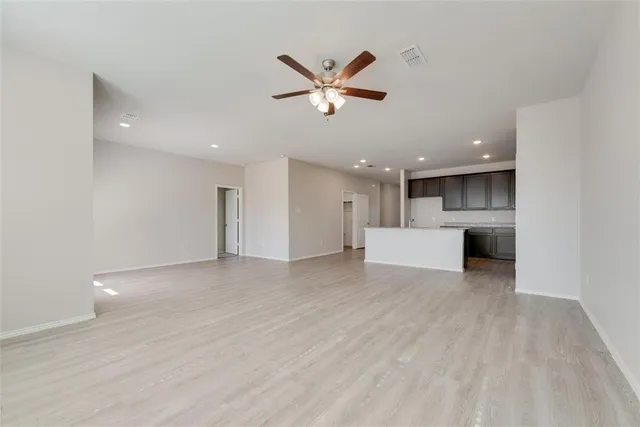 a view of a livingroom with a ceiling fan a ceiling fan and wooden floor