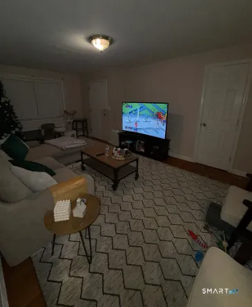 a living room with furniture a rug and a wall painting