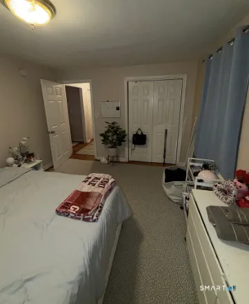 a bedroom with bed and a mirror