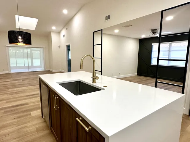a kitchen view with wooden floor and a sink
