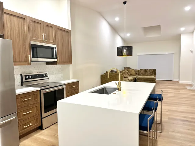 a kitchen with stainless steel appliances kitchen island granite countertop a stove a sink and a microwave