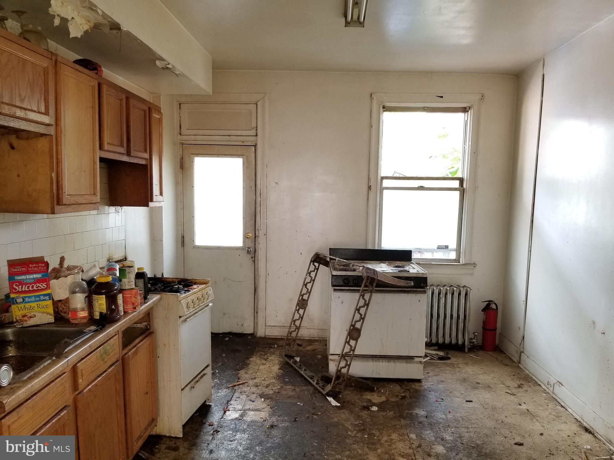2606 Grogan Avenue Baltimore, MD 21213 - Photo 4 of 9 a kitchen with a window a sink and a stove
