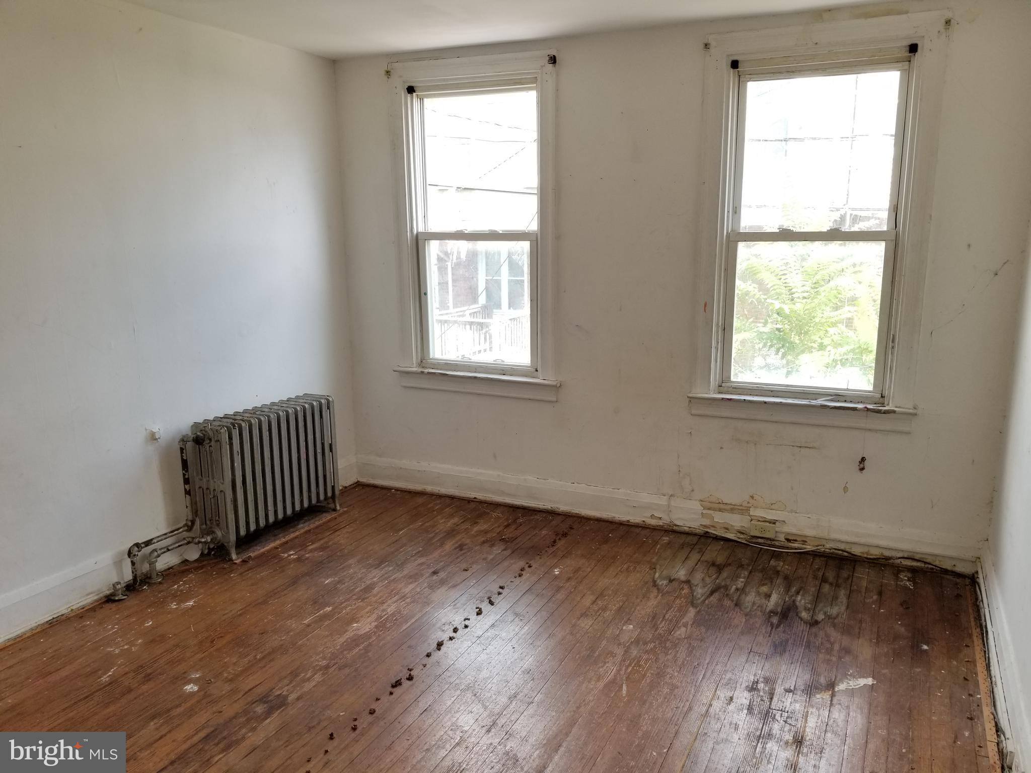 2606 Grogan Avenue Baltimore, MD 21213 - Photo 8 of 9 an empty room with wooden floor and windows