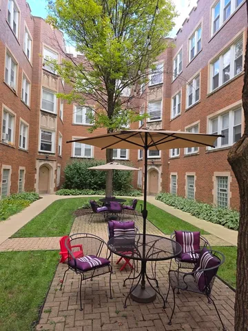 a view of a patio with a table and chairs
